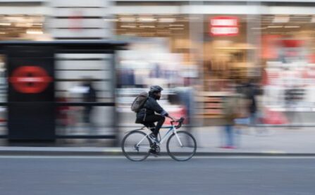 Solo blurred cyclist with drop handlebars and rucksack