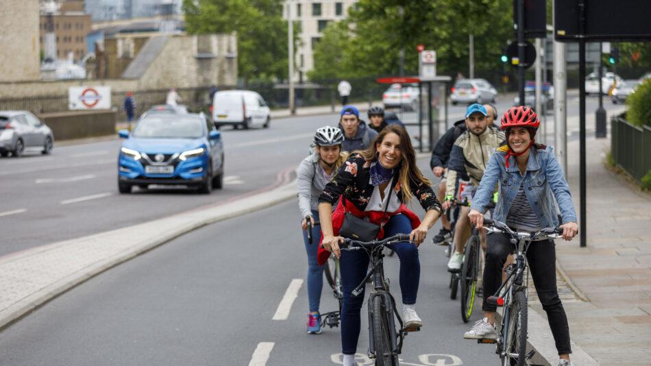 Women smiling cycling on cycle lane (cycle superhighway)
