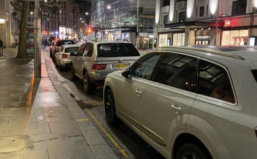Cars parked along Kensington High Street