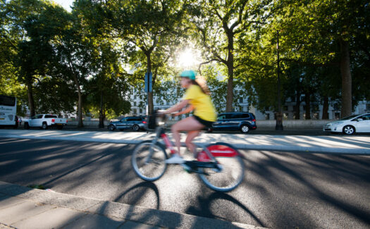 Woman cycling in sunshine on cycle lane (cycle superhighway)