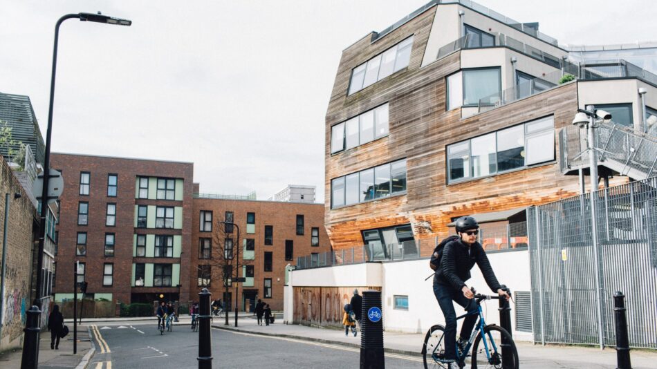 A cyclist riding past a new housing development