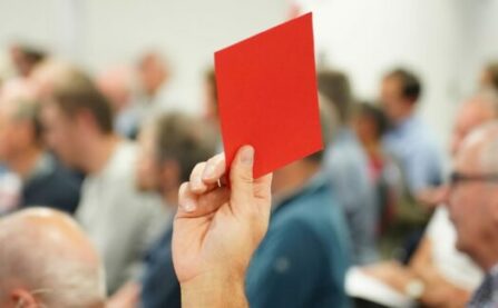 Person voting with red card at LCC AGM event
