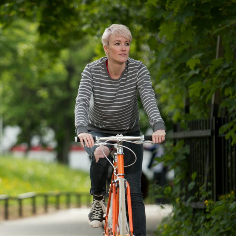 Woman cycling on orange bike