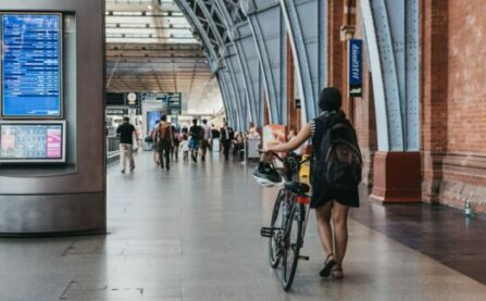 Woman with bike walking through train station