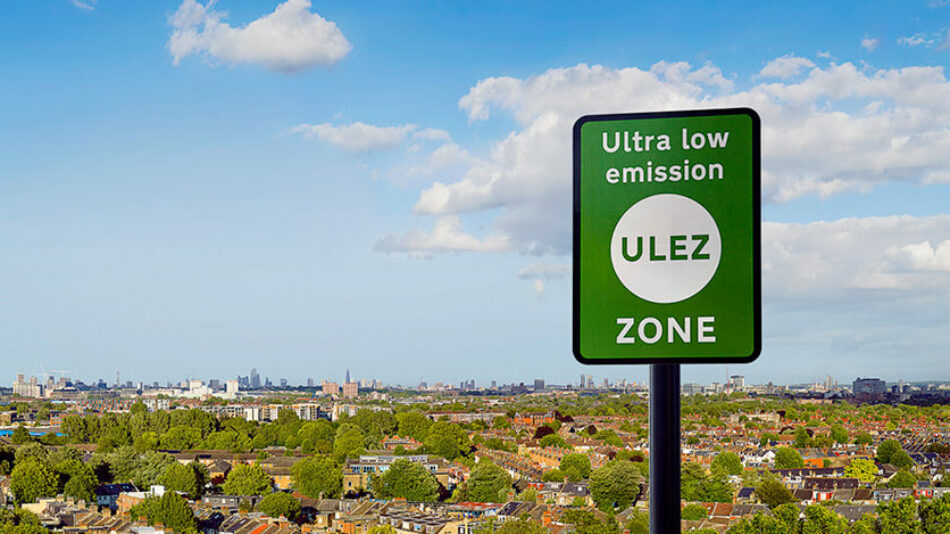 Green ultra low emissions zone sign in front of a landscape view