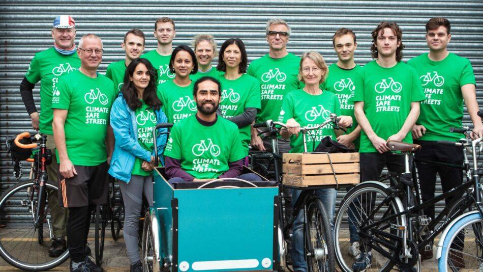 A group of Climate Safe Streets champions gathered around a cargo bike all wearing green tee shirts.