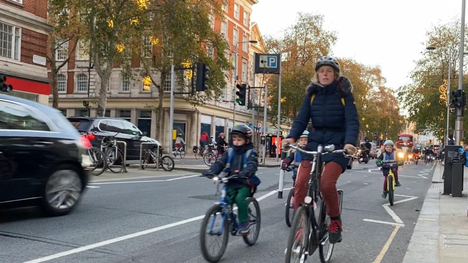 Parent with child cycling in painted cycle lane
