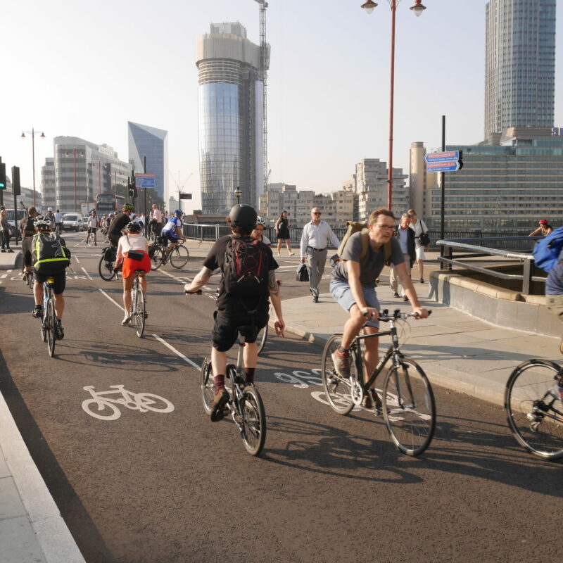 People cycling on a protected cycle lane (cycle superhighway)