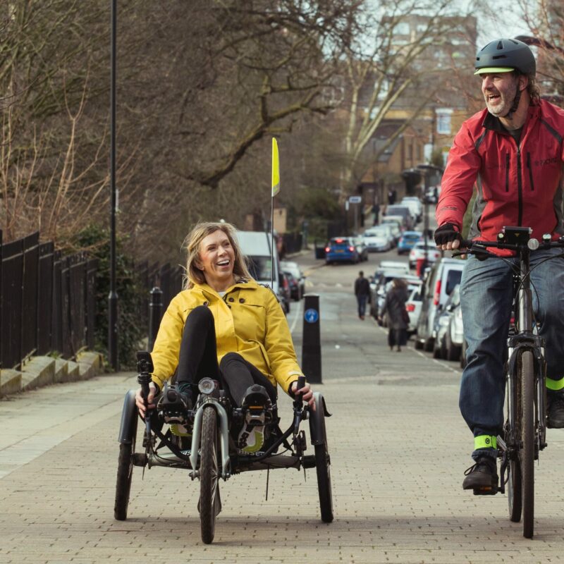 Man and woman on adapted cycle in cycle lane
