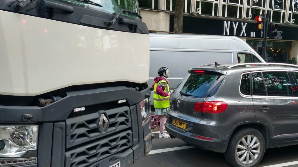 Woman cycling next to lorry at dangerous junction