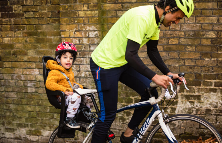 Man with child in seat on back of bike at Urban Hill Climb challenge event