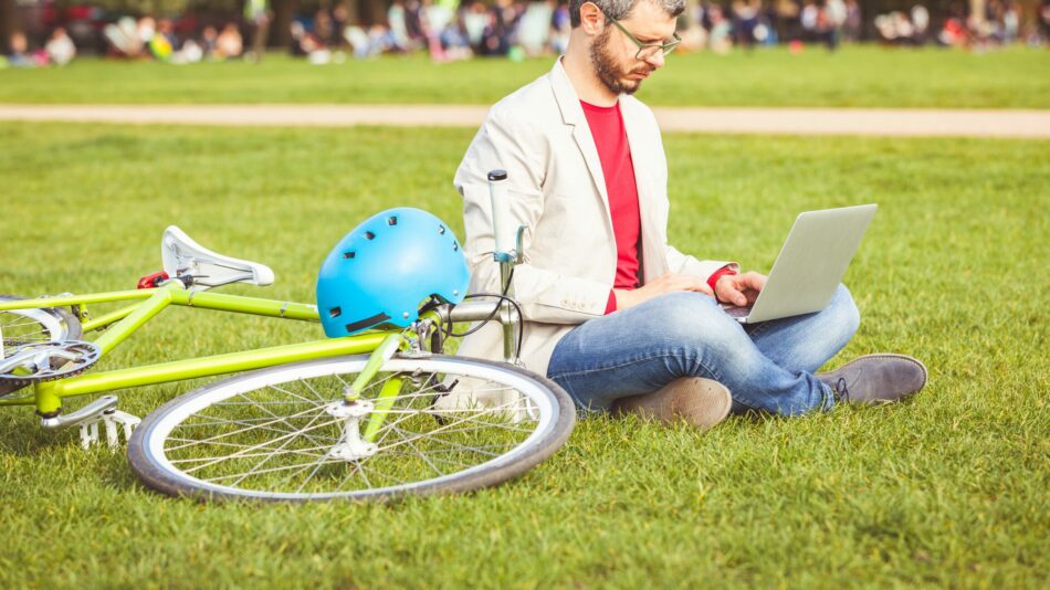 Man with bike and laptop in park