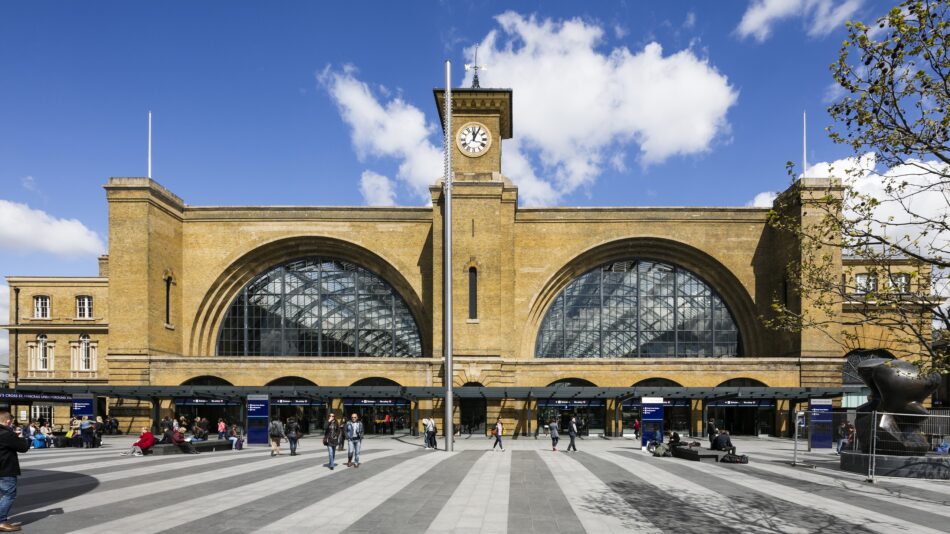 Frontage of King's Cross station with pedestrian plaza and iconic double arched windows